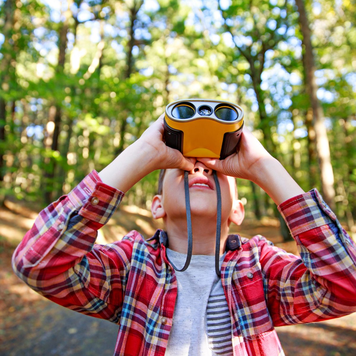 Boy looks up through binoculars.
