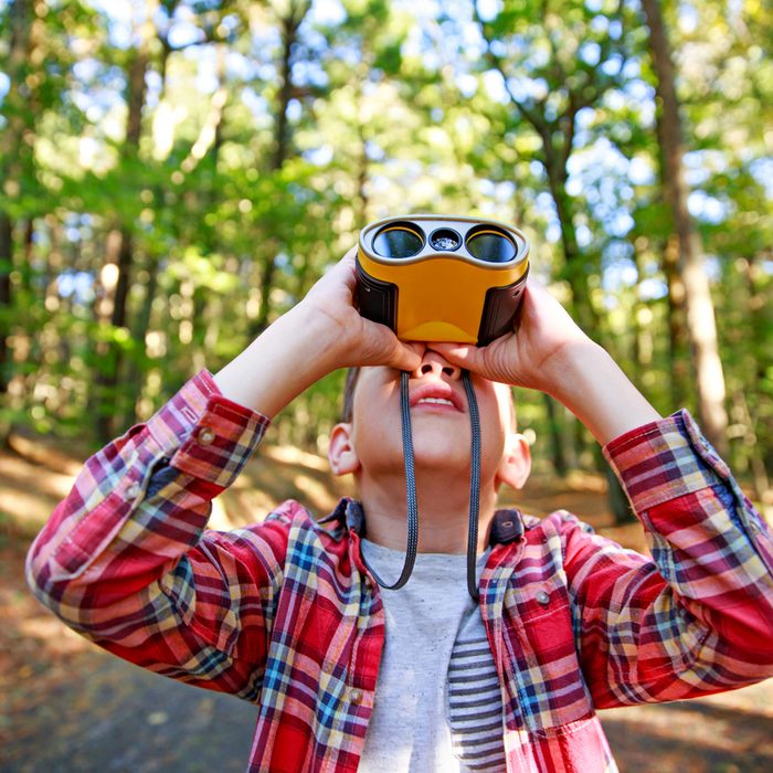 Boy looks up through binoculars.