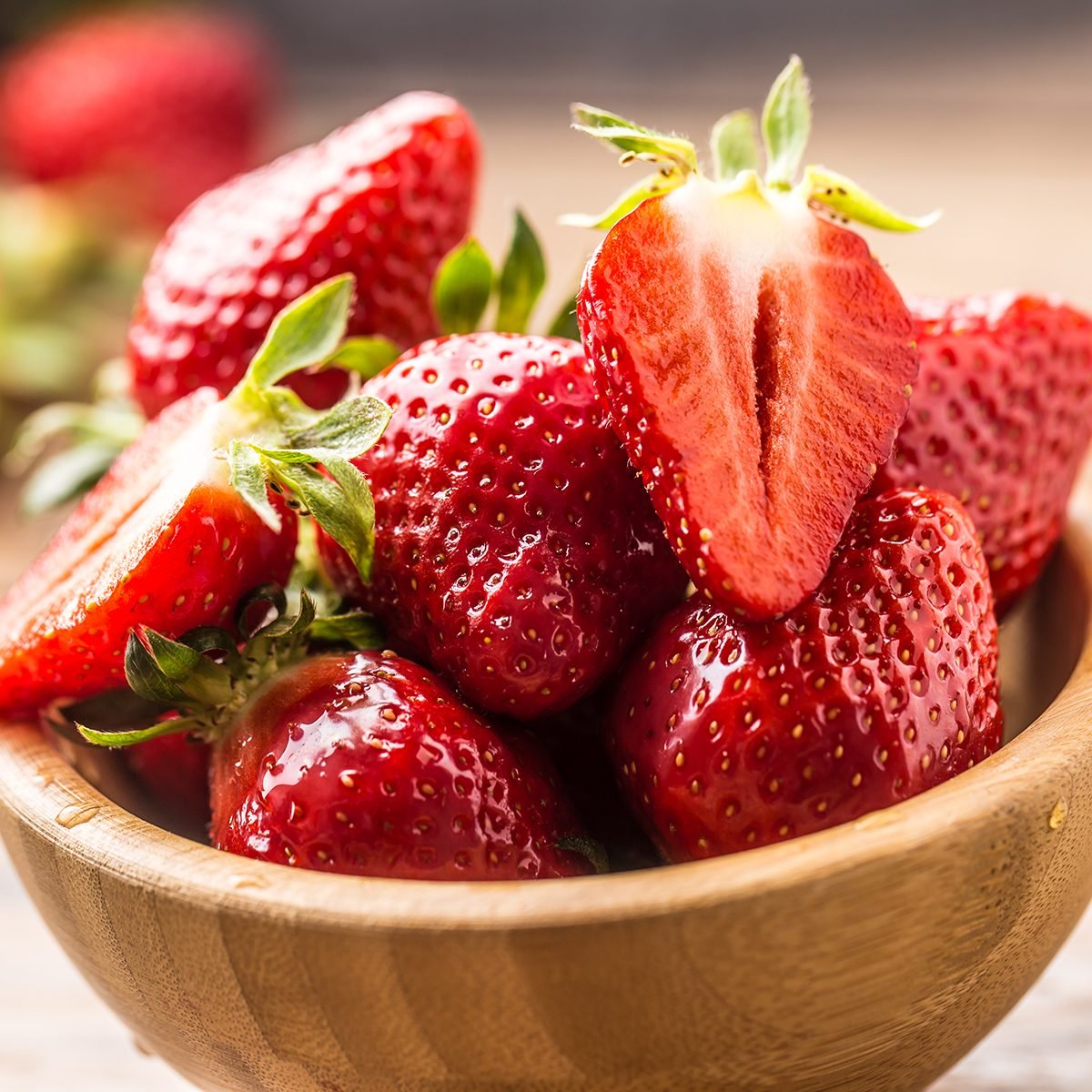 fruits for diabetics Juicy washed strawberries in wooden bowl on kitchen table.