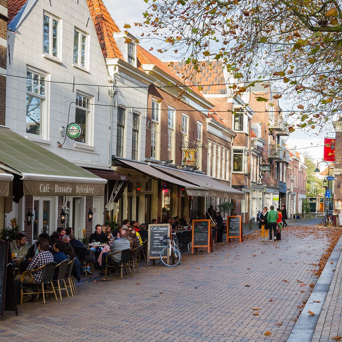 People sitting at outdoors restaurant in the main square of Delf.