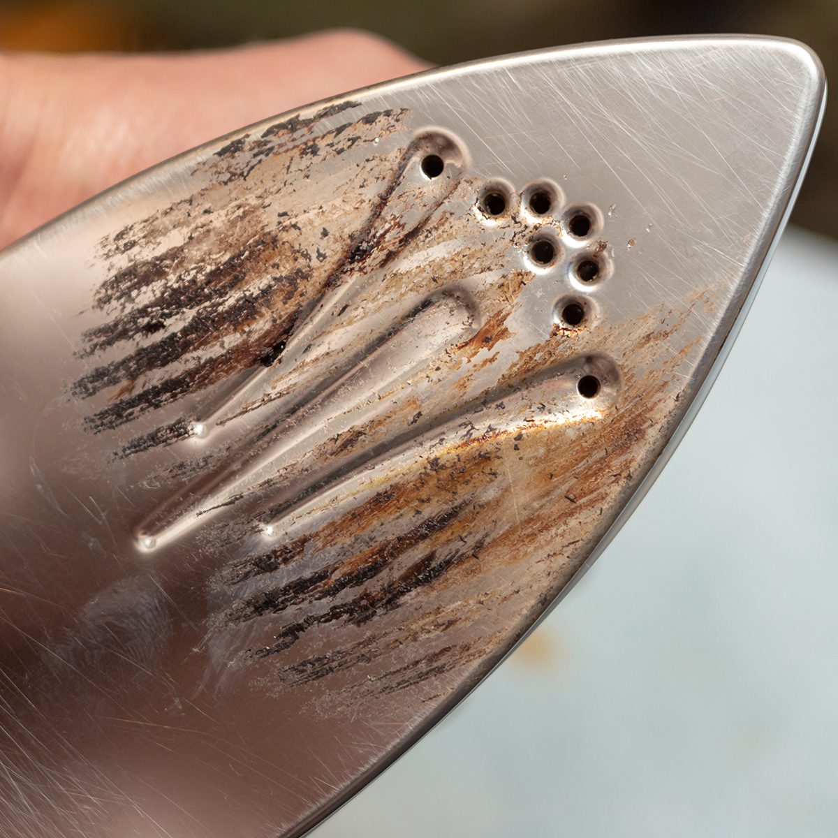 Removal of melted fibers and scrap hardened plastic on the soleplate. Cleaning the surface of the iron. Prevention of the soleplate surface from becoming scratched or corroded. Household concept; Shutterstock ID 1417566491; Job (TFH, TOH, RD, BNB, CWM, CM): TOH