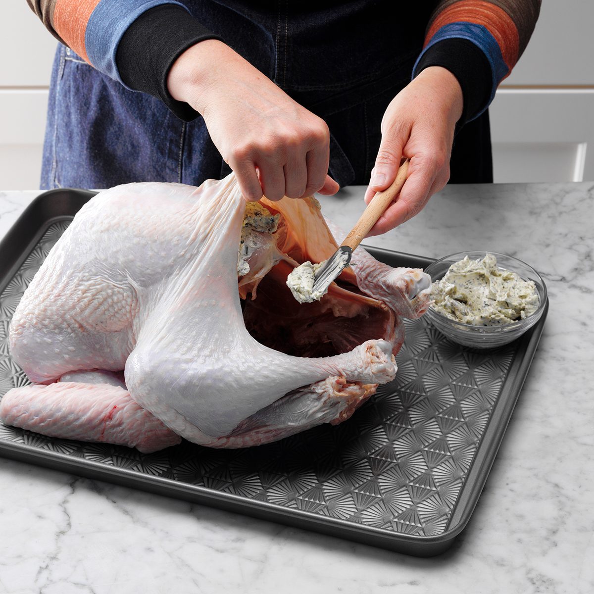 putting herb butter in raw turkey