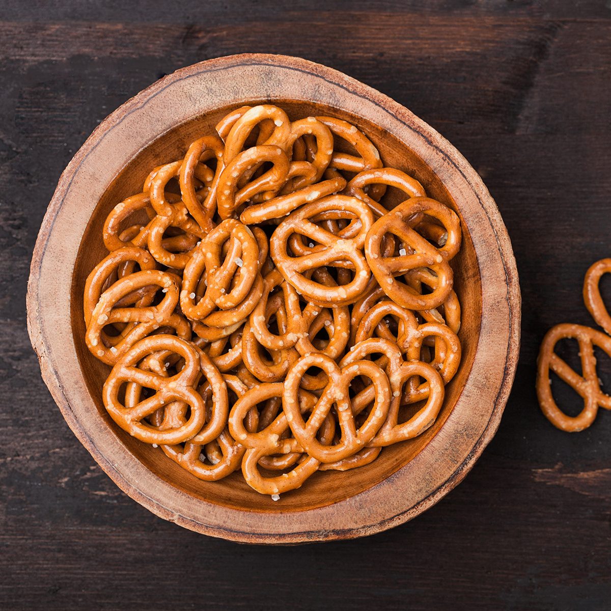 Hard salted pretzels classic snack for beer in wooden bowl on wood. Top view