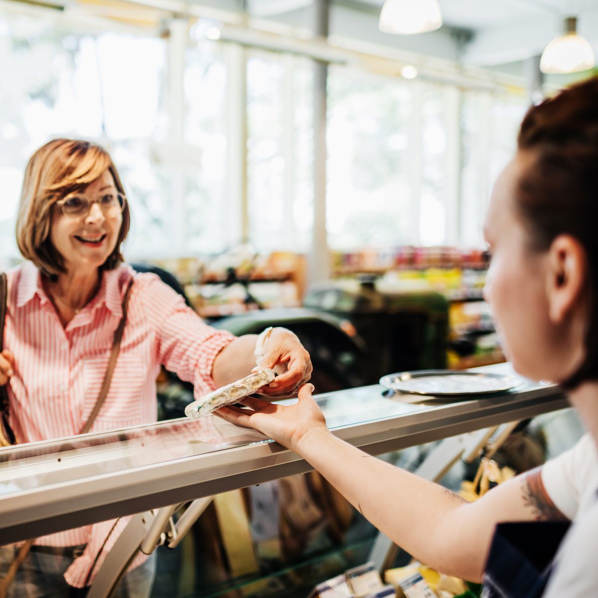 A mature couple picking out some cheese at their local delicatessen in the supermarket.