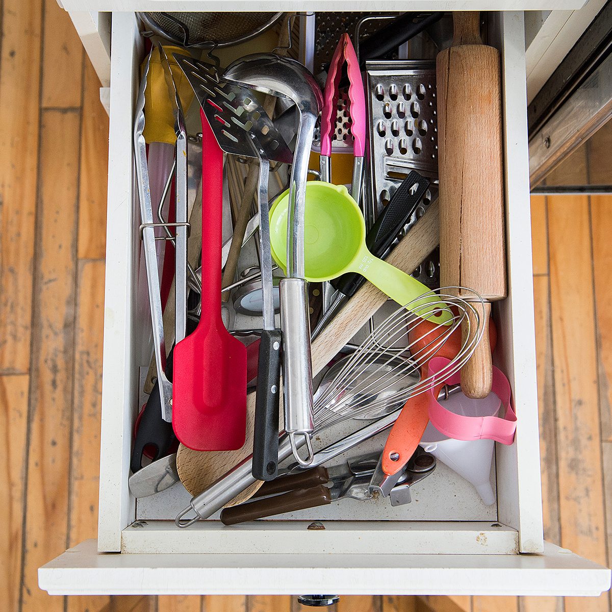a kitchen drawer packed with utensils is shown