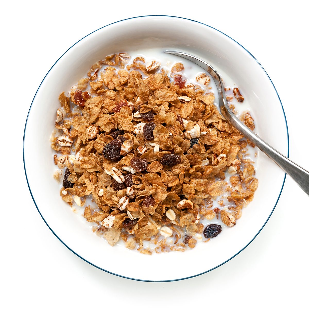 Bowl of cereal with spoon, isolated on white. Overhead view.