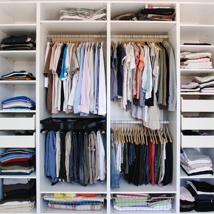 Open wardrobe inside. Men an women clothes.