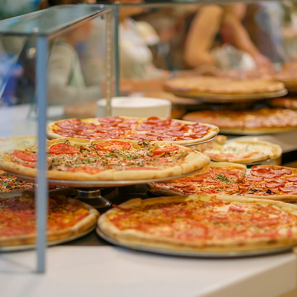 Variety of yummy pizzas under shopping window in pizzeria; Shutterstock ID 676292251