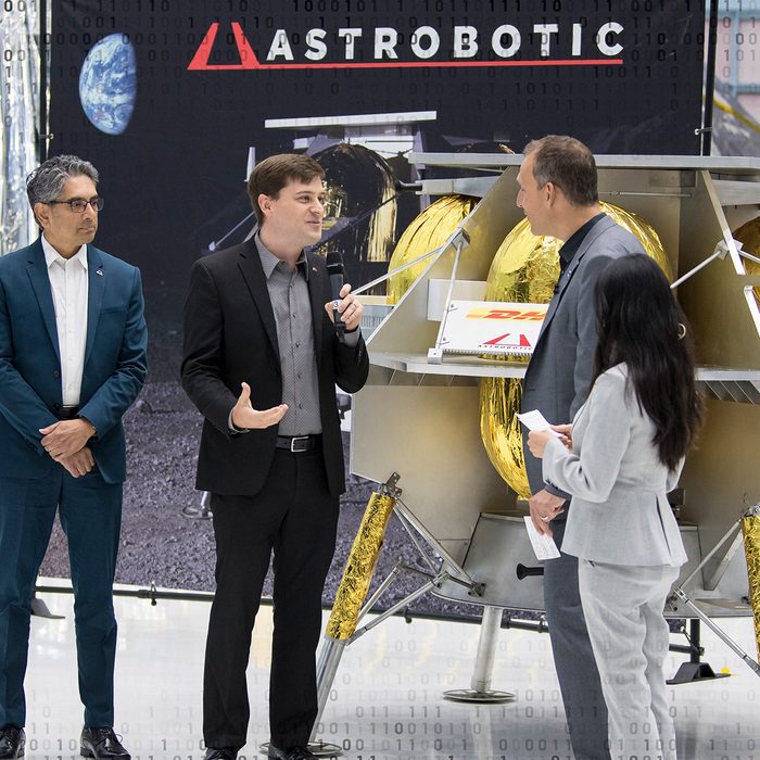 GREENBELT, MARYLAND - MAY 31: In this handout provided by the National Aeronautics and Space Administration (NASA), NASA Associate Administrator, Science Mission Directorate, Thomas Zurbuchen, second from right, speaks to Astrobotic CEO, John Thornton, second from left, and Astrobotic Mission Director, Sharad Bhaskaran, left, about their lunar lander, May 31, 2019, at Goddard Space Flight Center in Maryland. Astrobotic, Intuitive Machines, and Orbit Beyond have been selected to provide the first lunar landers for the Artemis program