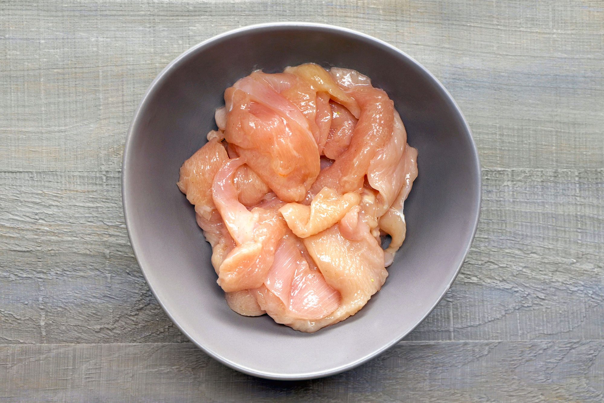 Mixing Chicken with Salt, Pepper and Oil in a Bowl