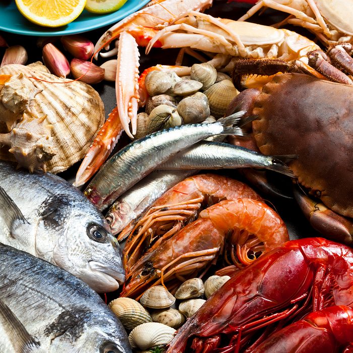 High angle view of a large group of seafood like fish, crustacean and mollusk. The composition includes two sea bream, giant red shrimp, prawn, crab, clam and scallop. DSRL studio photo taken with Canon EOS 5D Mk II and Canon EF 100mm f/2.8L Macro IS USM