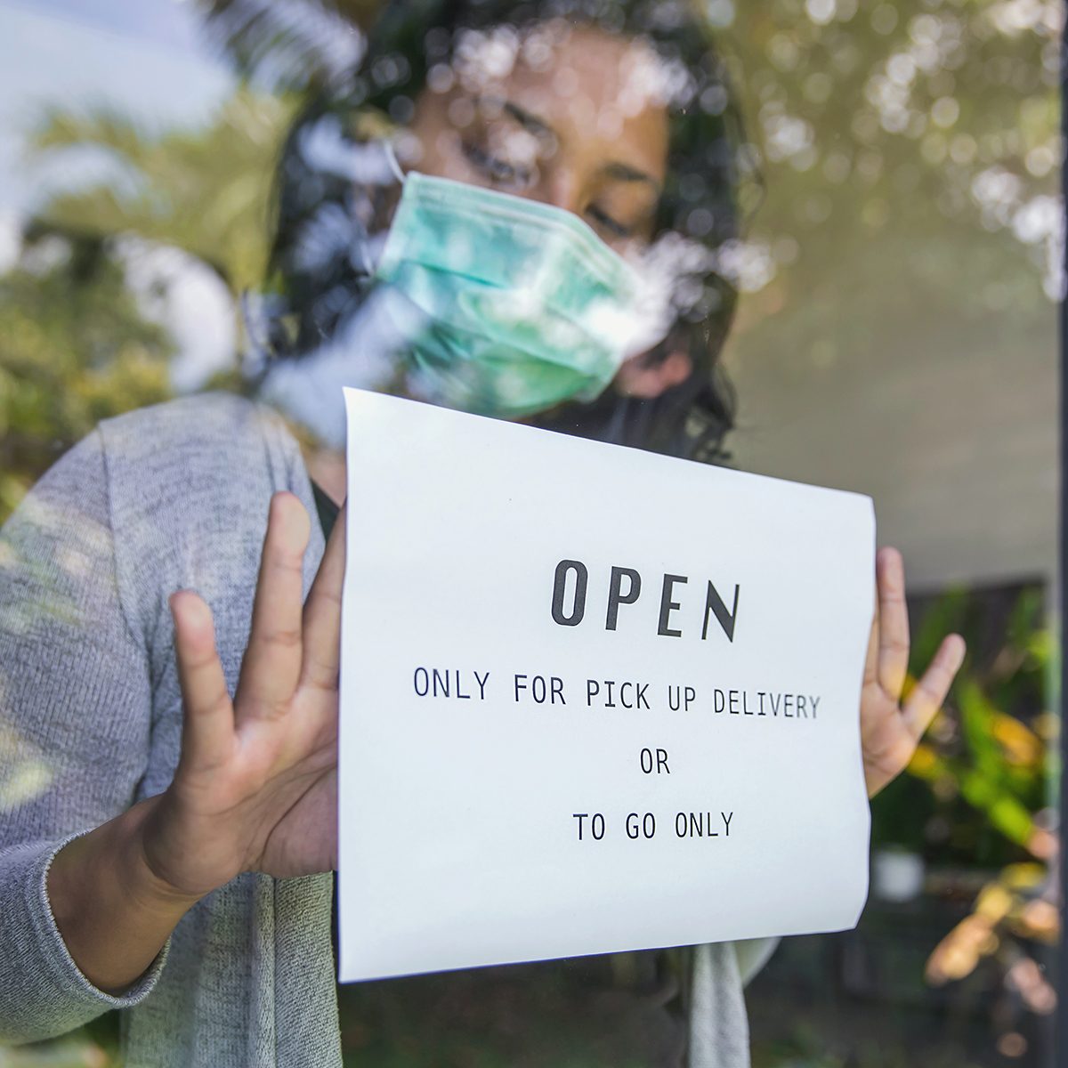 Close up shot of business owner putting open sign restaurant , but only for pick up delivery and take away food only, during Covid 19 pandemic