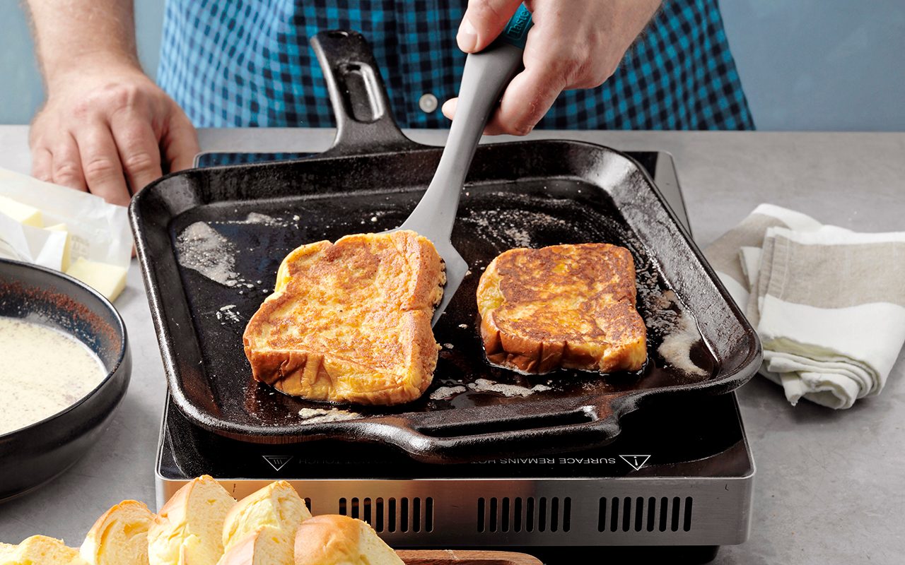 how to make french toast The Best French Toast; How to Step 6; flip to other side; cook to golden brown; half-and-half cream; egg yolks; brown sugar; vanilla extract; ground cinnamon; ground nutmeg; brioche bread; butter; maple syrup; fresh berries; whipped cream; confectioners' sugar; powder sugar; hands