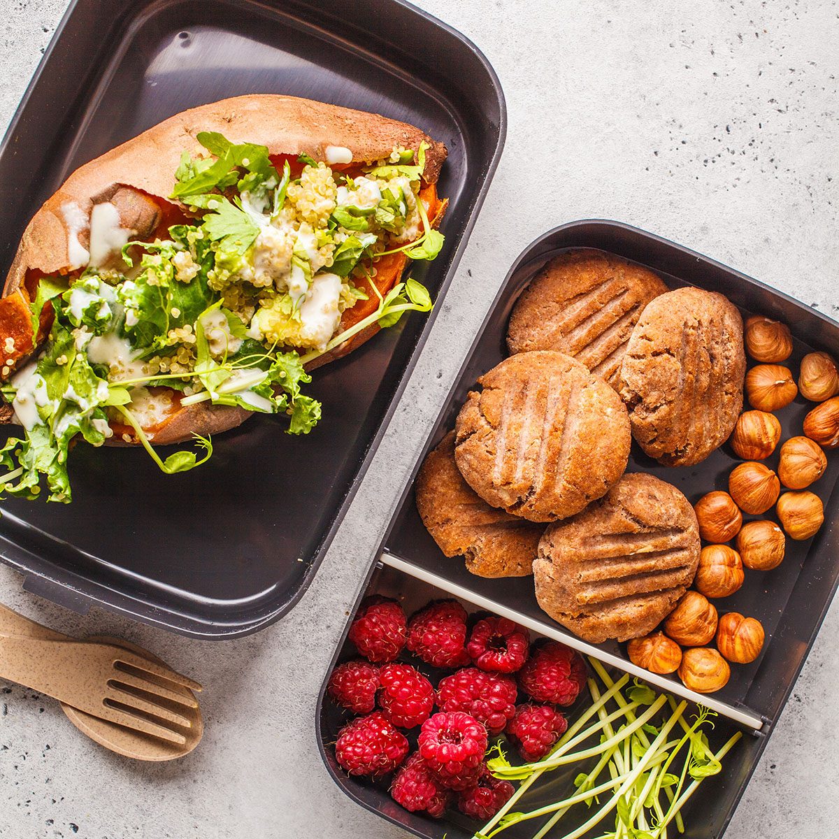 Healthy meal prep containers with quinoa Stuffed Sweet Potatoes, cookies, nuts and berries, overhead shot