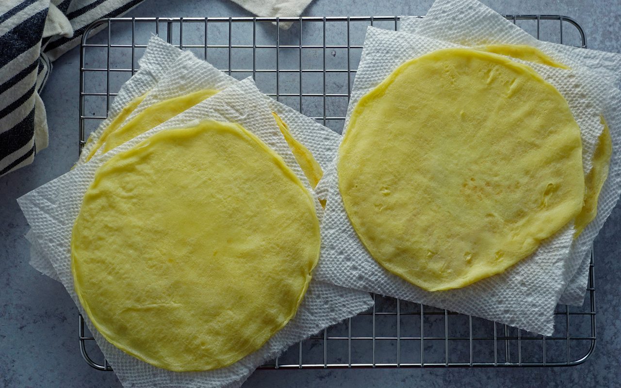 cooling the cooked blintzes on a wire rack separated by paper towel or waxed paper