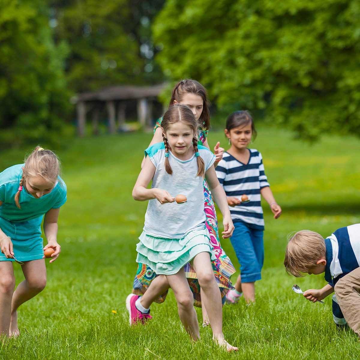 Group of children competing in an egg-and-spoon race in a park, Munich, Bavaria, Germany