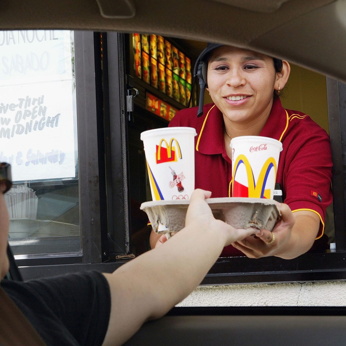 REDWOOD CITY, CA - JULY 29: Josephine Hernandez hands a tray of drinks to a drive thru customer at a McDonald