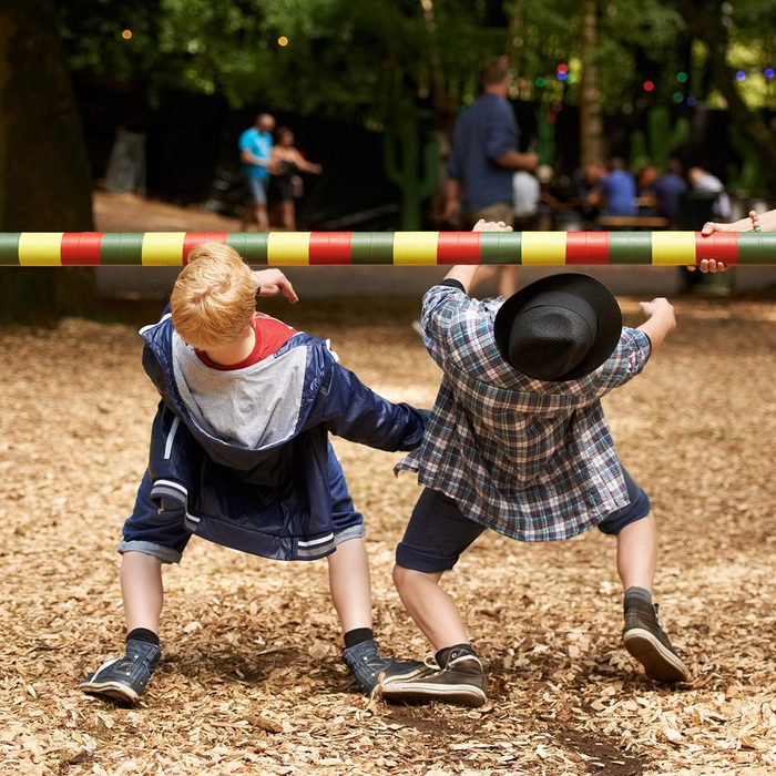 Shot of two kids doing the limbo at an outdoor festival