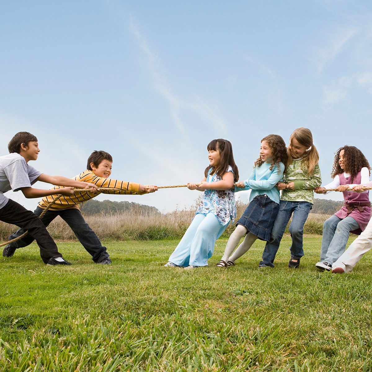 Multi-ethnic children playing tug-of-war
