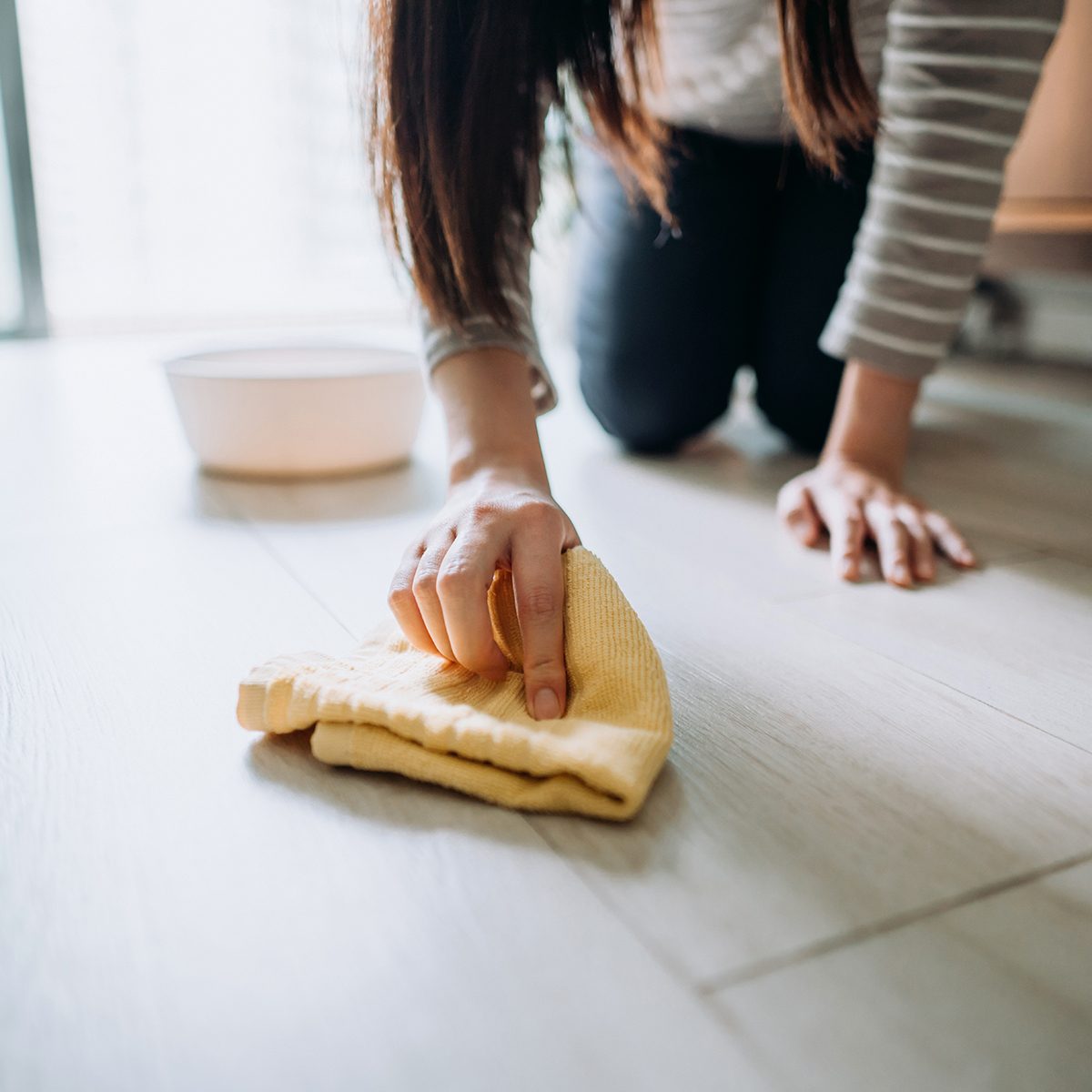 Cropped shot of a young woman cleaning the floor with a cloth at home during the day