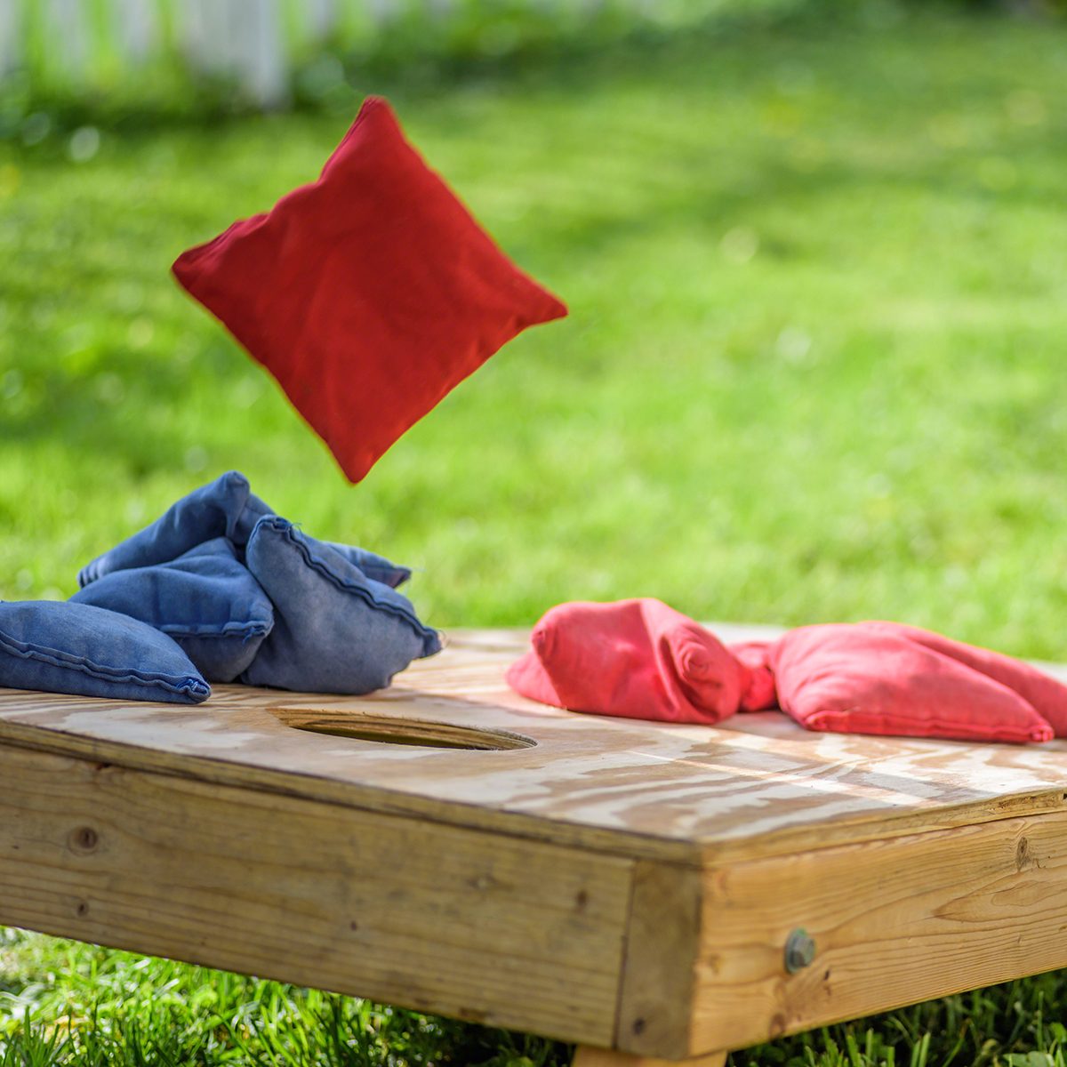 Homemade corn hole board game in grass in summertime