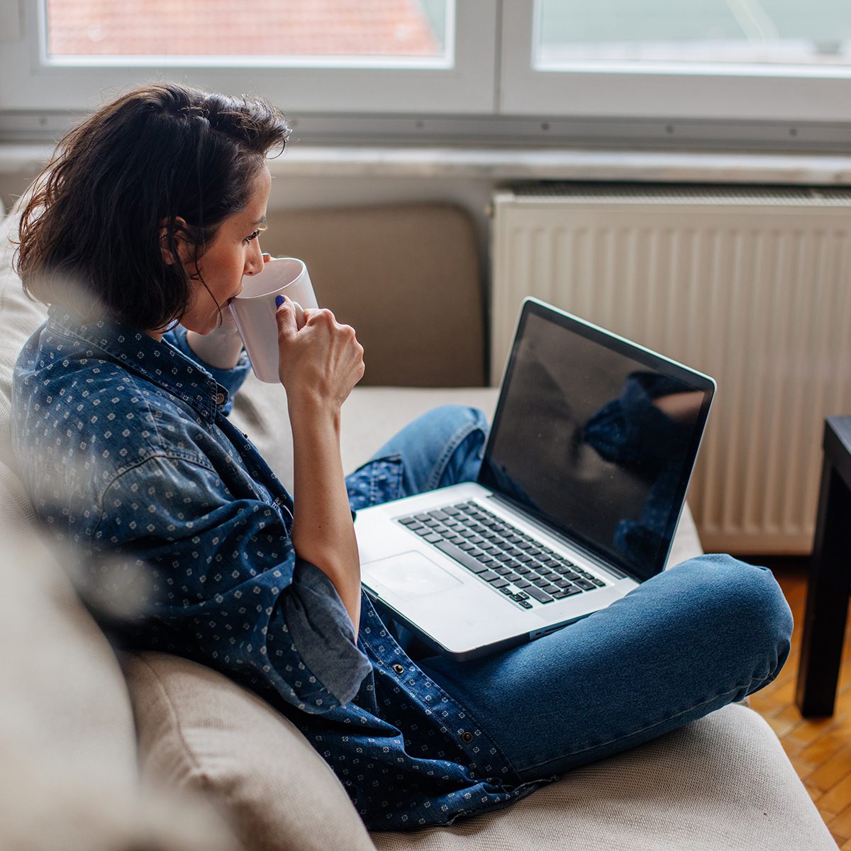 Cropped image of woman using laptop with blank screen