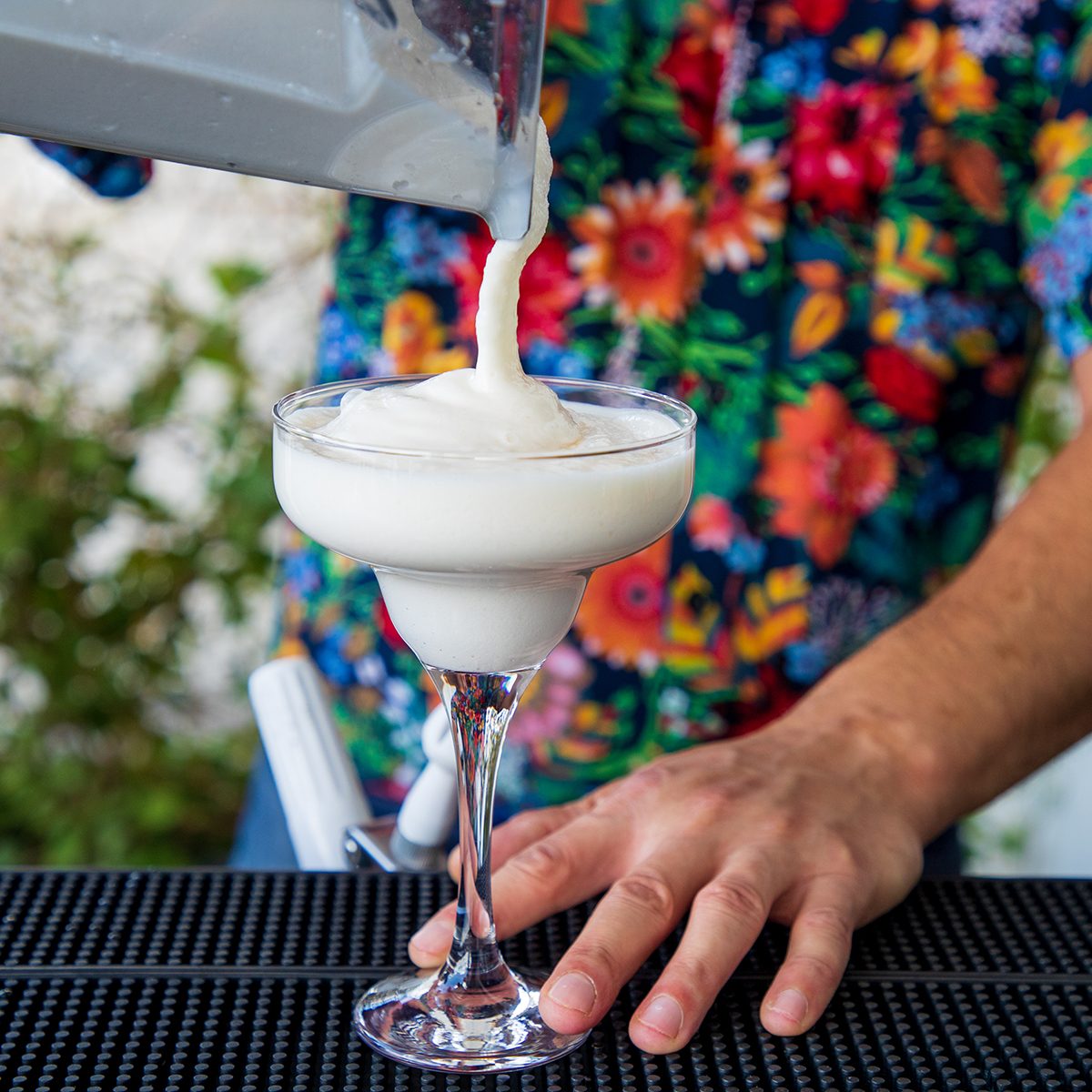 how to make frozen drinks Pouring White Smoothie Into Cocktail Glass