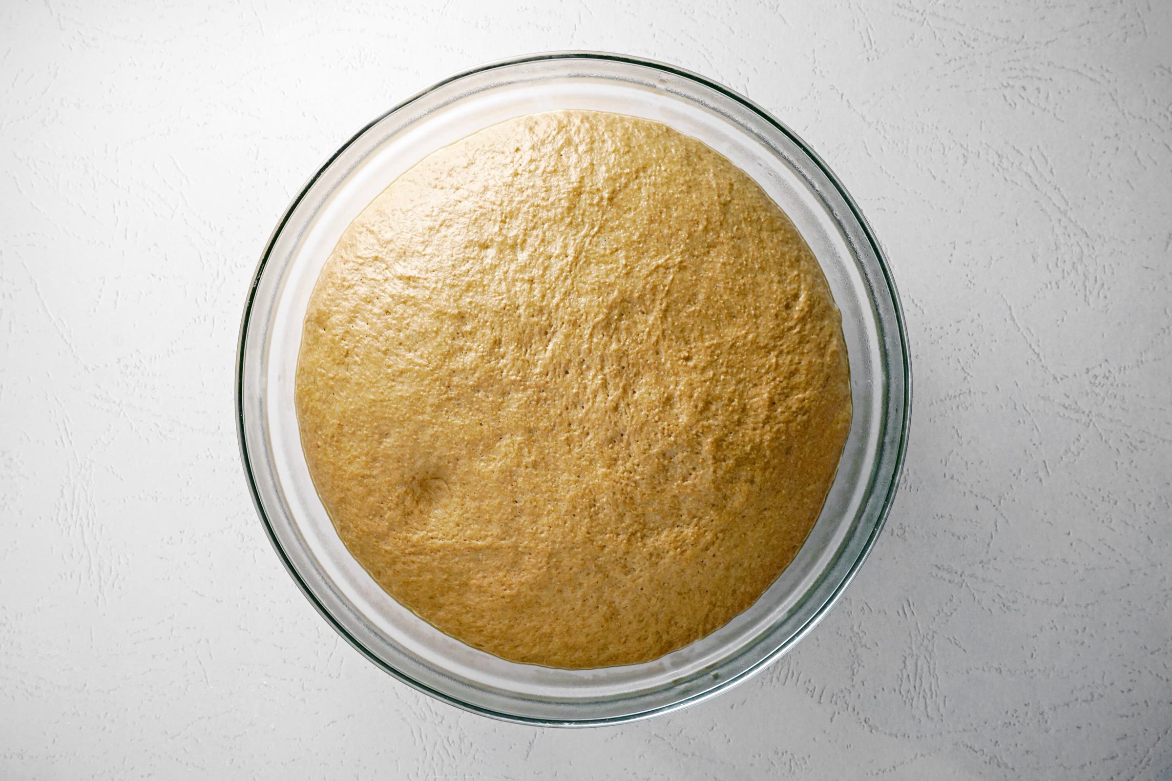 Cheesecake Factory Brown Bread dough rising in a glass bowl