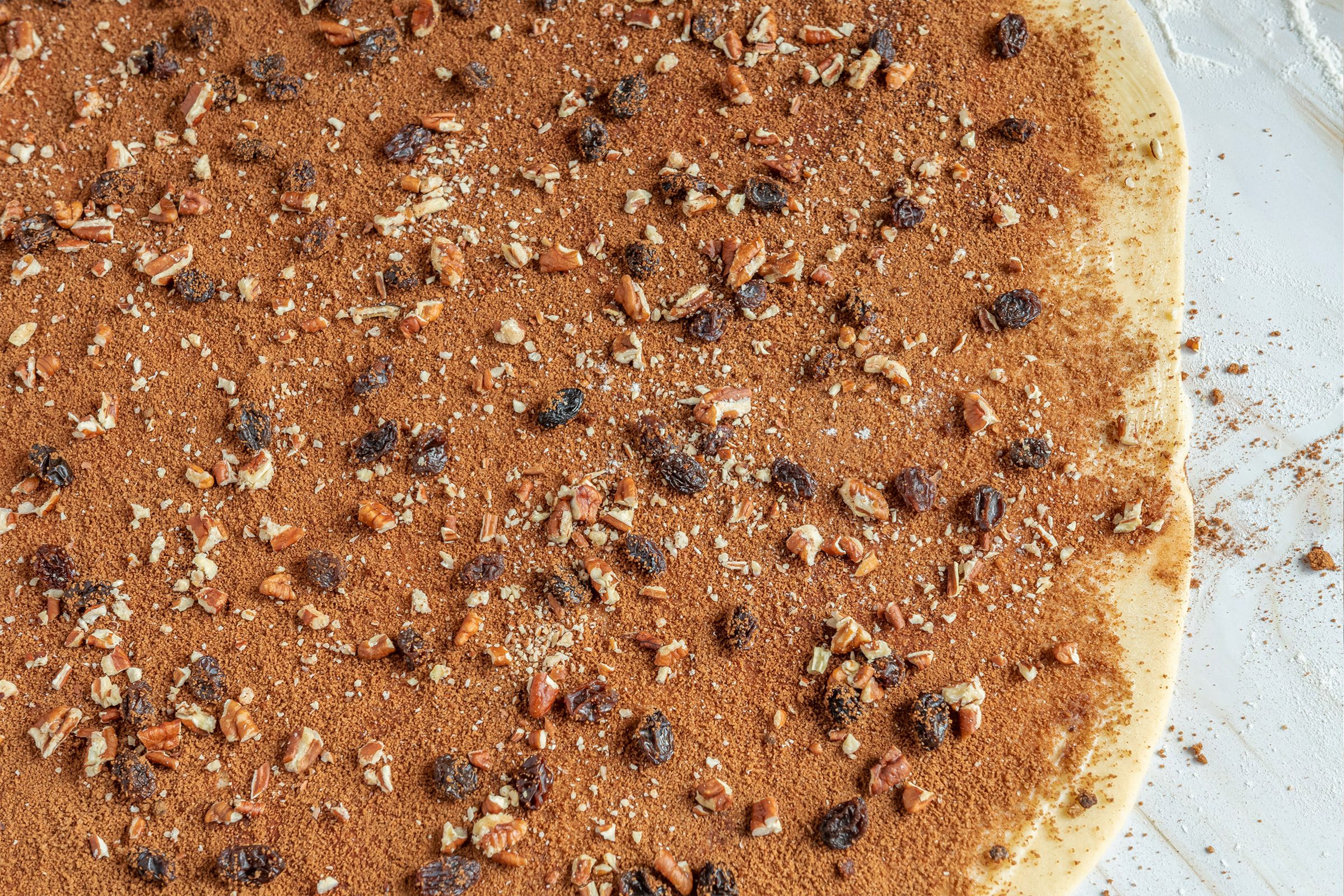 rolled out dough with filling spread on top for domino sugar cinnamon rolls