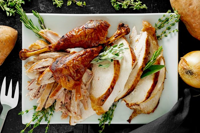 carved turkey slices sitting on a white rectangular plate, view from above