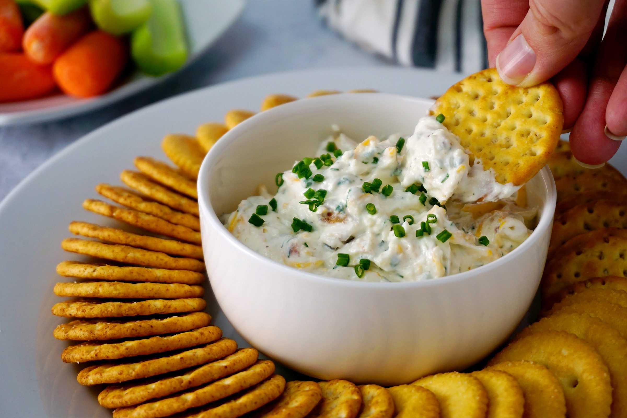 Dipping a cracker into the Loaded Hidden Valley Ranch Dip