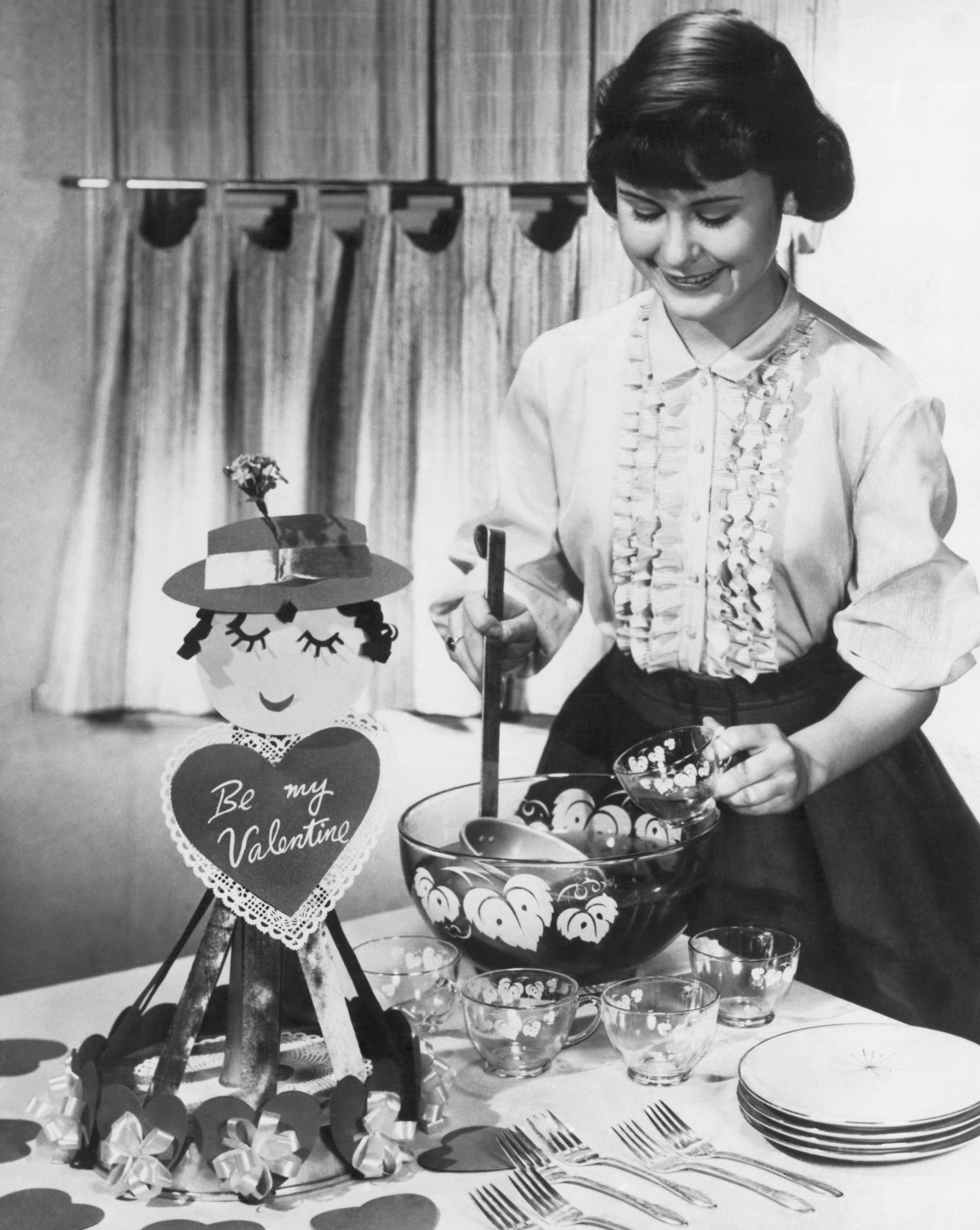 A young woman teenager serves punch at a Valentine