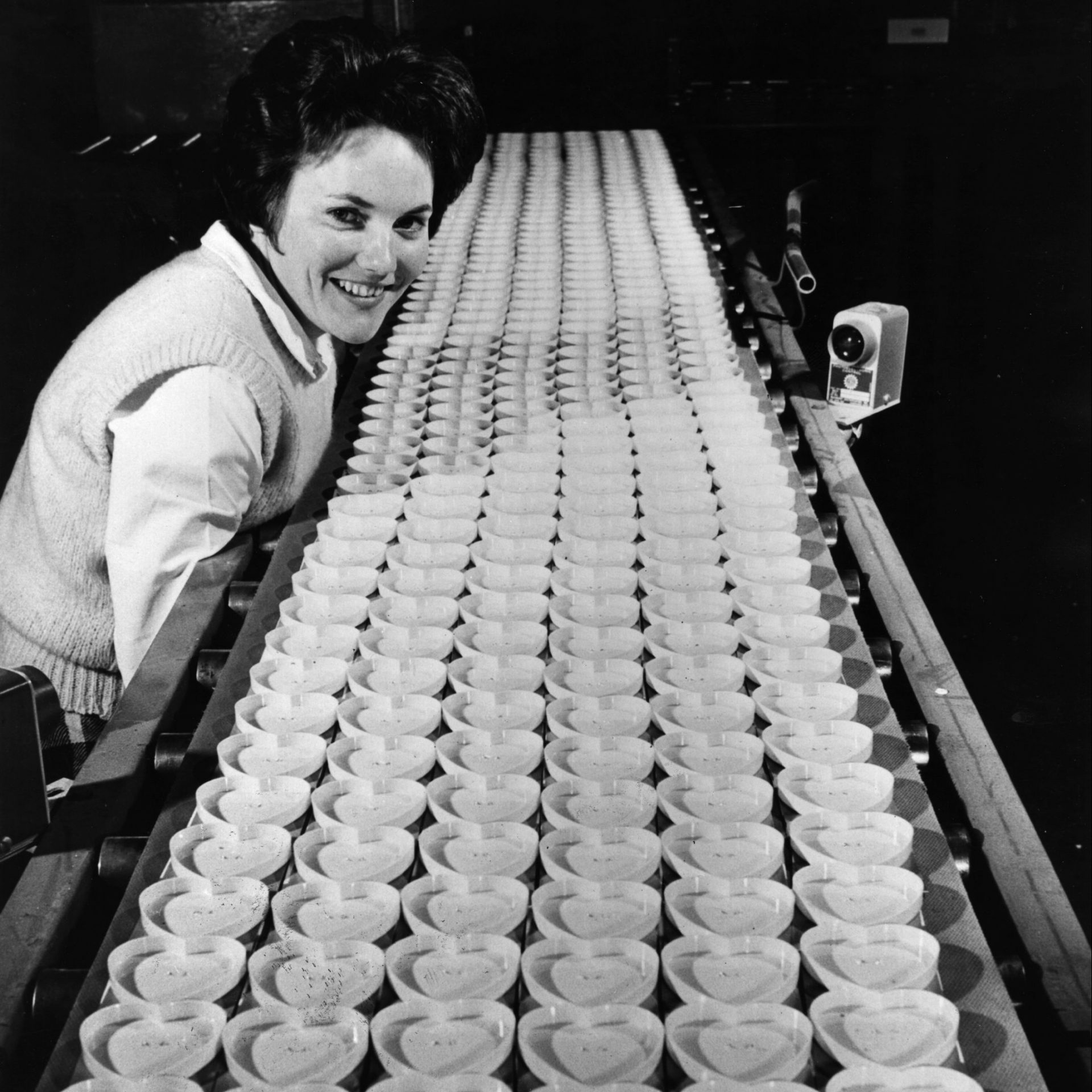 A factory worker checks an endless line of heart-shaped containers which will be filled with straight pins for Valentine