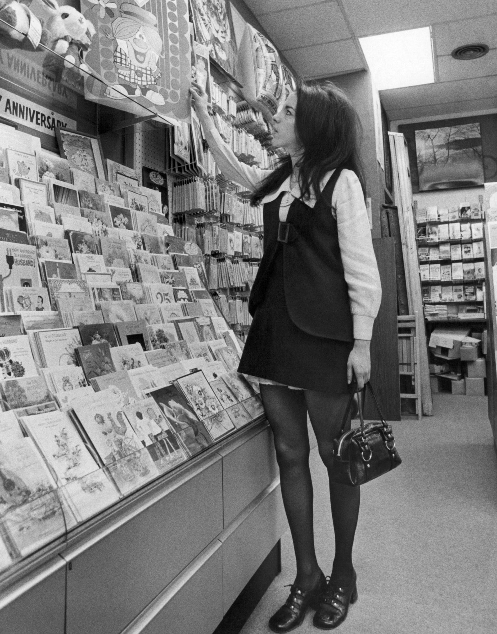 iew of a young woman in a mini skirt as she shops for a comically oversized Valentine