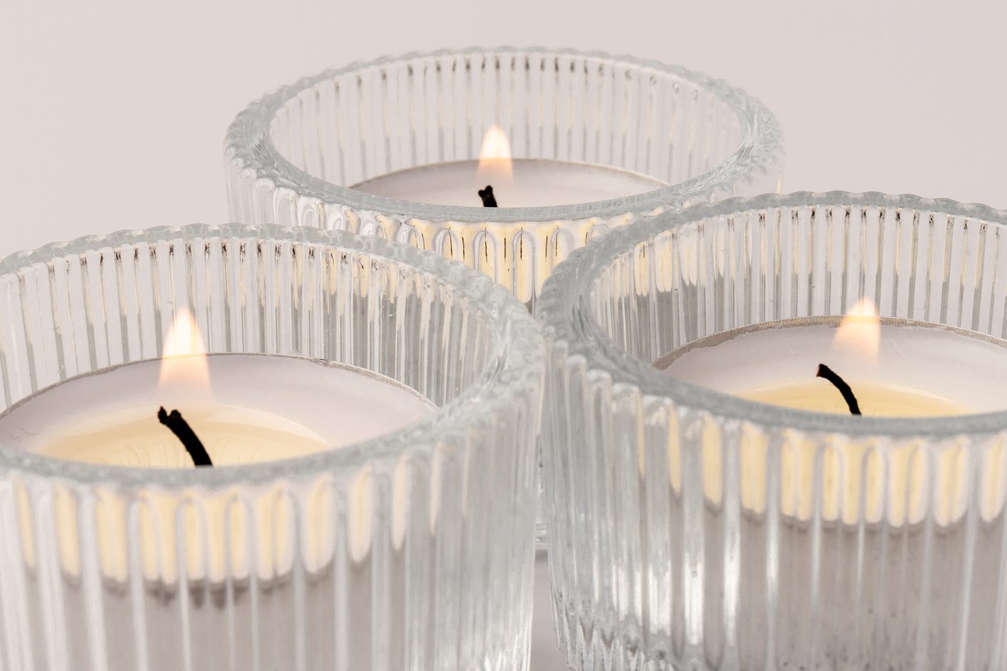 Burning tea candles in a glass holder, isolated on white. Space for text