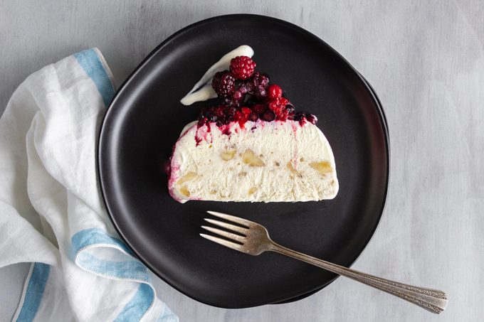 slice of Jello Frozen Pudding Dessert from 1968 with berries on a black plate