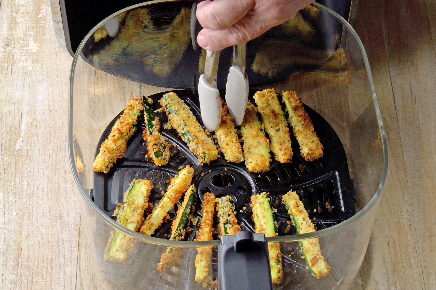 high angle shot of zucchini fries in air fryer basket