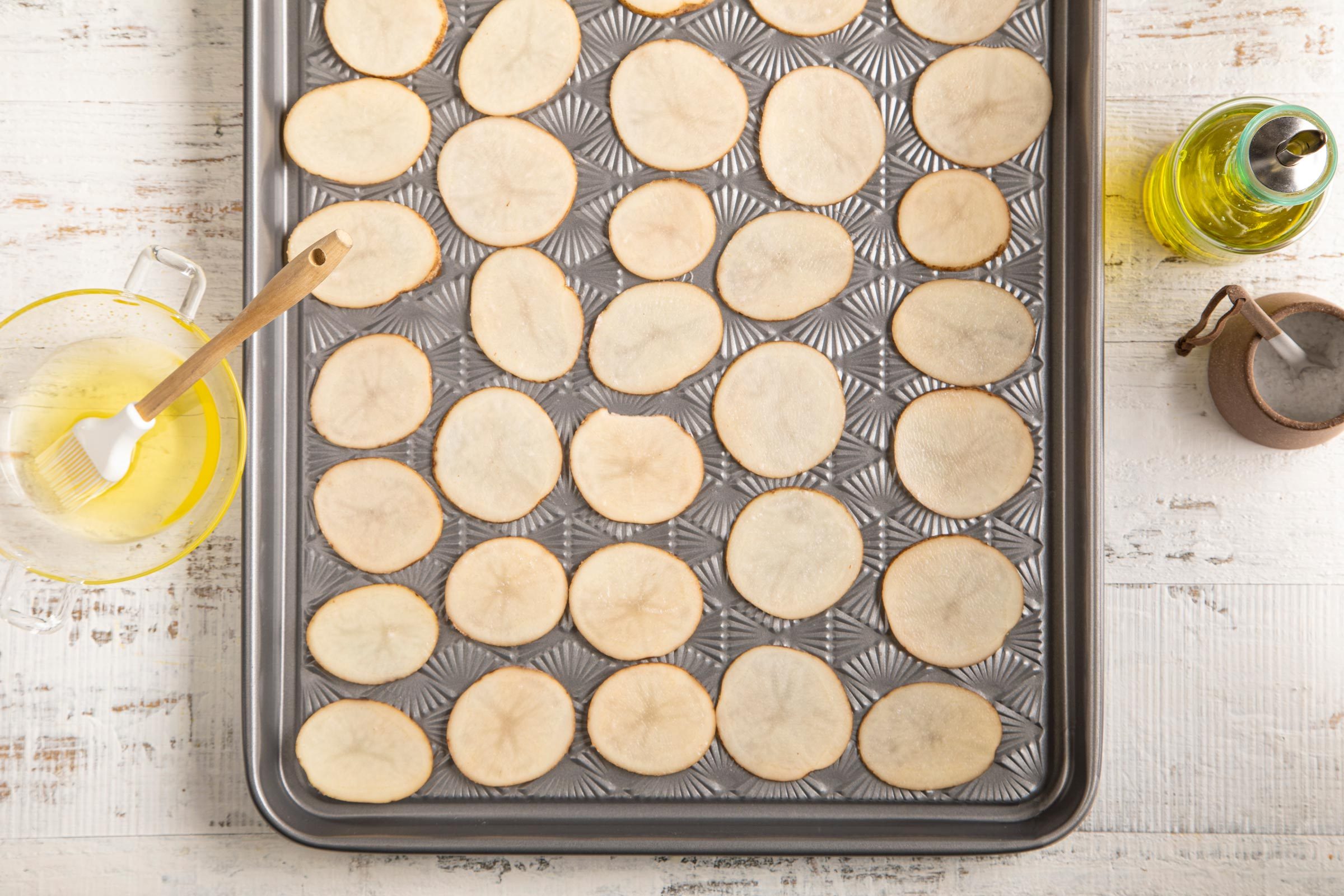 raw potato slices on a baking sheet
