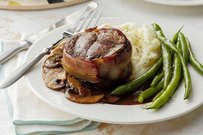 Air Fryer Bacon Wrapped Filets served on plate with beans
