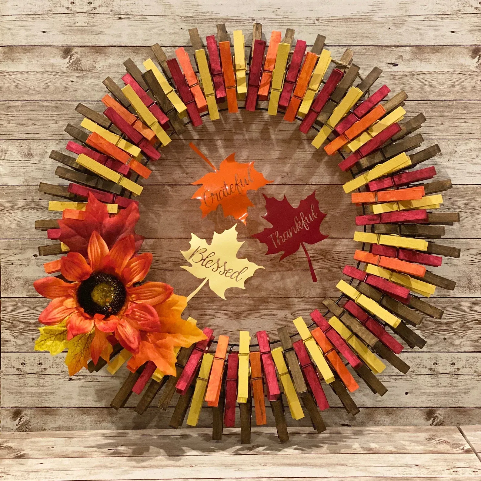fall clothes pin wreath with faux lflowers and leaves as an accent