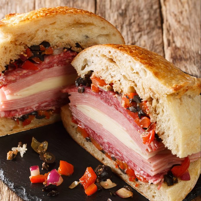 Muffaletta Sandwich with Homemade Bread and Olive Salad close-up on the table