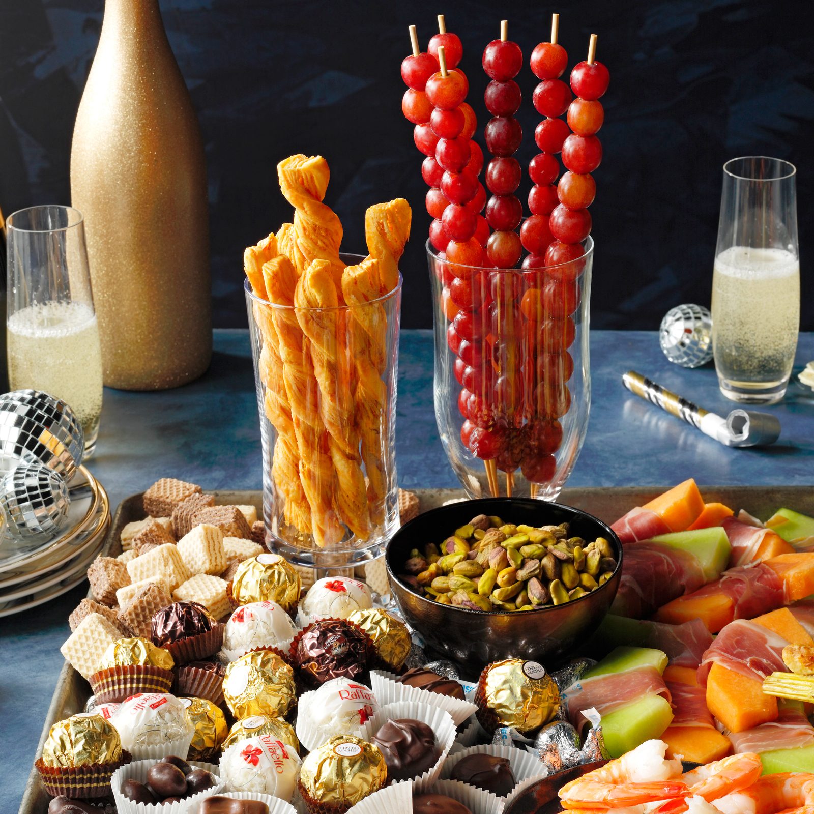 a New year's themed charcuterie board on a decorated table