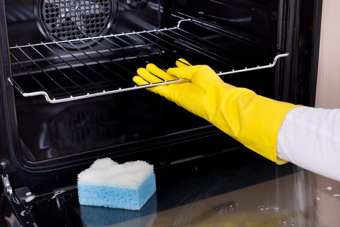 Woman cleaning oven