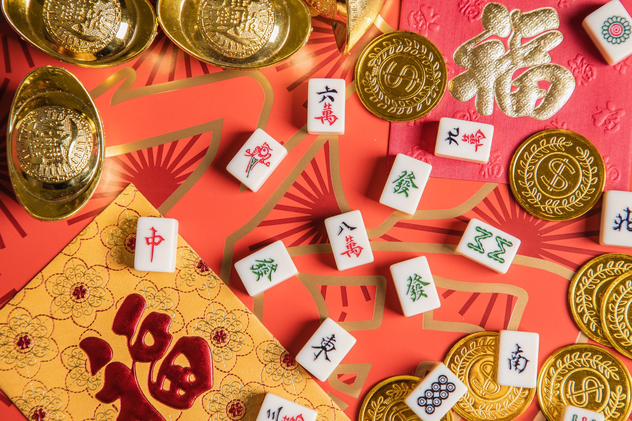 Chinese new year theme still life- gold ingot, gold coin, mahjong and red envelop