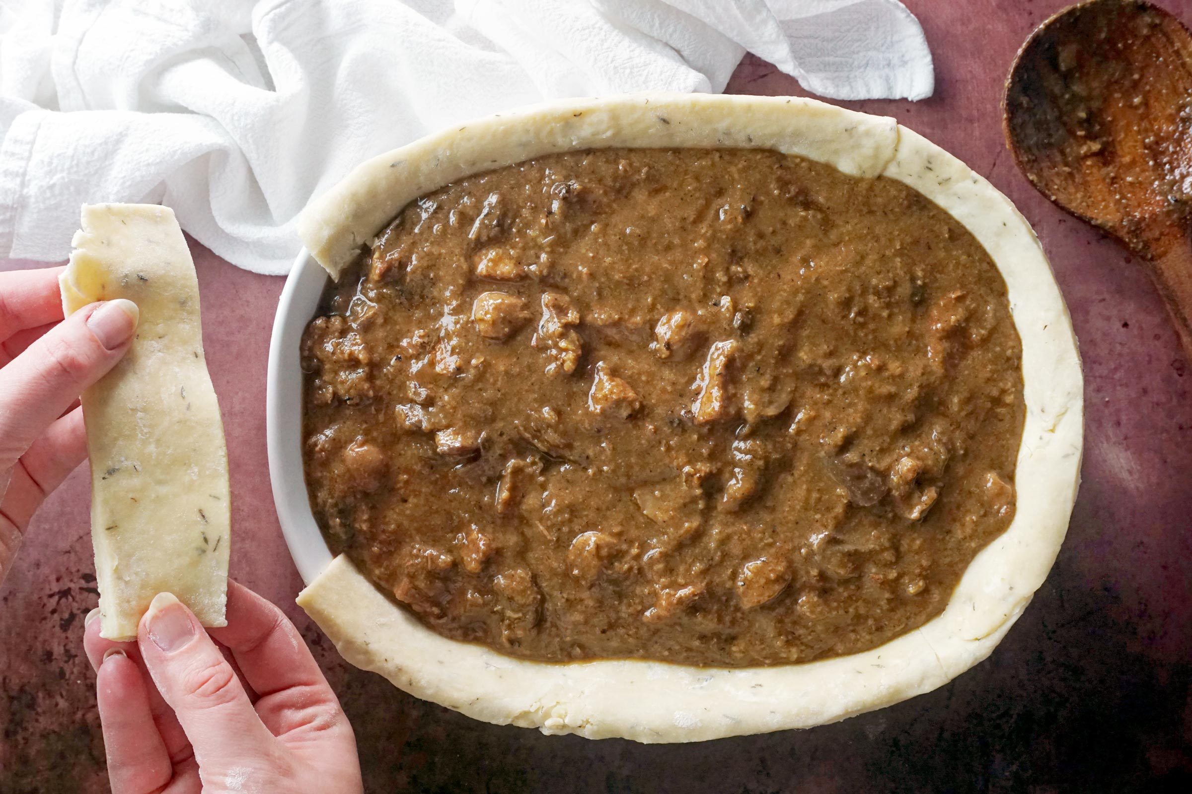 cutting dough into strips to finish making the pie crust