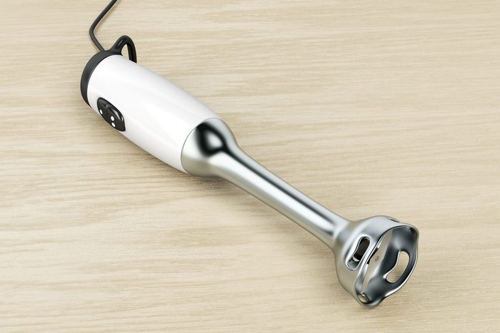 Hand blender on wood background