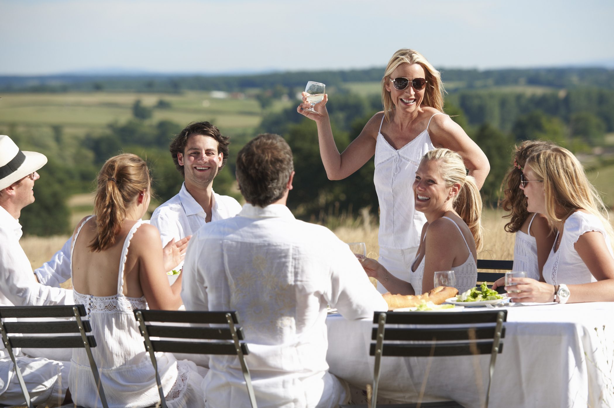 Woman toasting at table outdoors