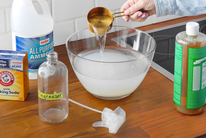 hand combining ingredients to make the homemade degreaser