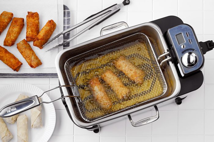 top view of egg rolls in a deep fryer