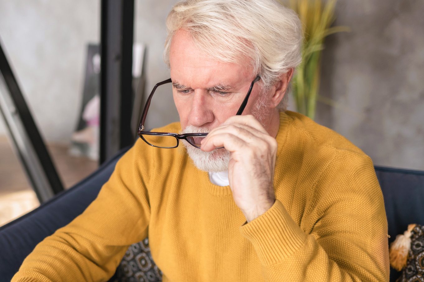 Senior man putting on glasses t o read the fine print